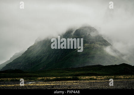 Niedrige Wolken über einen remote Mountain minimal Landschaft von South Island hängen. Stockfoto