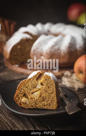 Landhausstil Apple Bundt Cake bestreut mit Puderzucker auf alten Holztisch Stockfoto