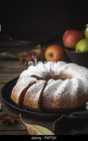 Landhausstil Apple Bundt Cake bestreut mit Puderzucker auf alten Holztisch Stockfoto