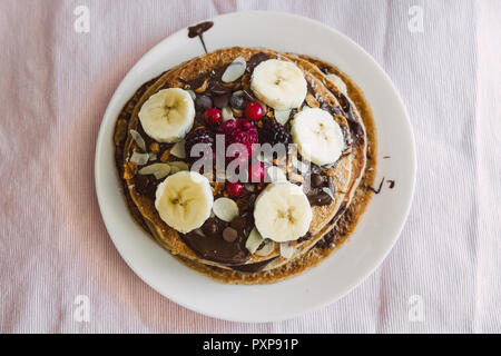 Vegane Pfannkuchen mit Früchten und Schokolade. Stockfoto