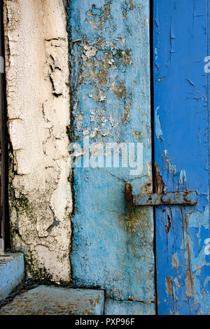 Alte Farbe auf ein Fenster und eine Tür, die in Blau und Weiß Stockfoto