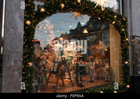 Basel, Schweiz, 25. Dezember 2017: Puppen und Spielzeug auf Anzeige im Spielzeugmuseum Fenster für Weihnachten mit Girlanden und Kugeln dekoriert Stockfoto