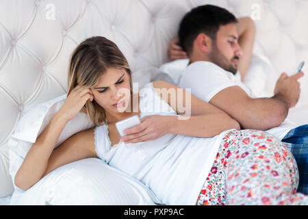 Bild von gelangweilten jungen Paares im Schlafzimmer Stockfoto