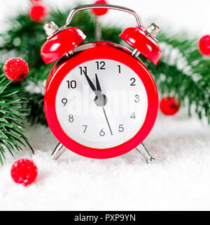 New Year's Clock und Tannenbaum Äste auf Schnee. Weihnachten Grußkarte. Stockfoto