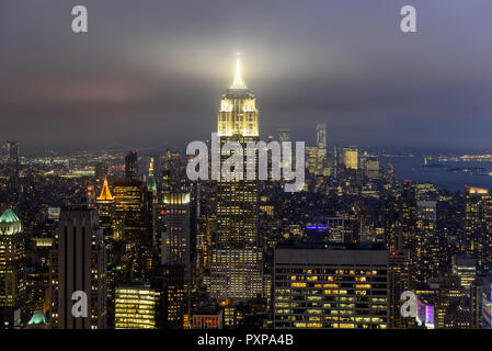 USA, New York City, Manhattan Skyline mit Blick auf das Empire State Building am Abend, vom Rockefeller Center, oben auf dem Felsen Stockfoto