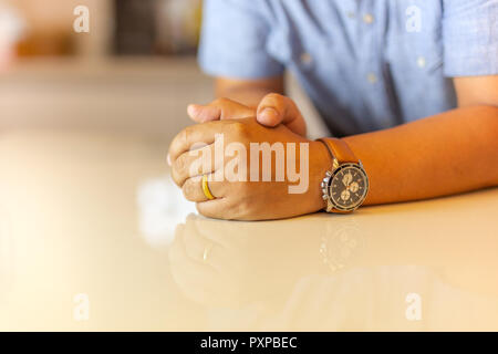 Die linke Hand mit gold Hochzeit Ring an seinem Finger auf Marmor tisch. Stockfoto