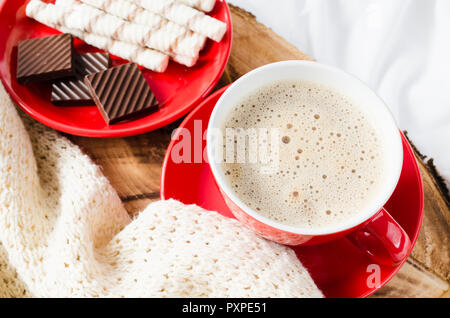 Frühstück im Bett. Fach mit Cappuccino und Schokolade auf einem Bett mit Plaid im Schlafzimmer Innenraum. Selektive konzentrieren. Stockfoto