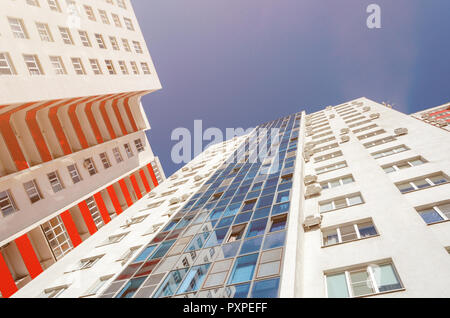 Anzeigen eines Wohnhauses von unten nach oben. Weißes Haus mit roten Balkone in einem warmen sonnigen Tag Stockfoto