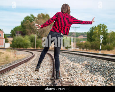 Eine Person, die Balance zu bewahren, zu Fuß entlang der Bahngleise Stockfoto