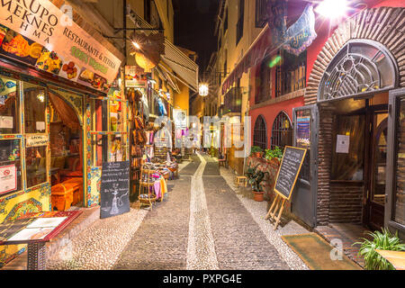 Granada, Andalusien, Spanien - 16 April 2016: typische Restaurants und Geschäfte in einer ruhigen Straße des beliebten alten maurischen Viertel Albaicin nachts beleuchtet. Im historischen Zentrum von Granada. Stockfoto