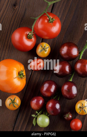 Organische Hausgewachsene heirloom Tomaten in verschiedenen Größen und Farben. Von violett Indigo Rose, rote und gelbe Kirschtomaten. Künstlerische noch Leben auf Stockfoto