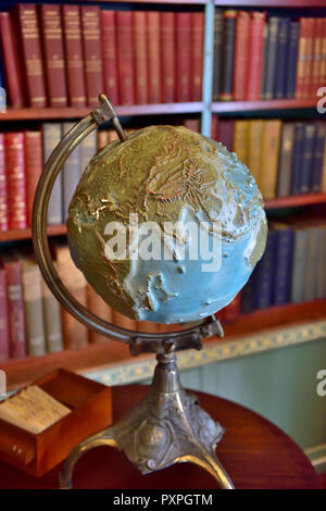 World Globe in Bibliothek mit Büchern hinter Stockfoto