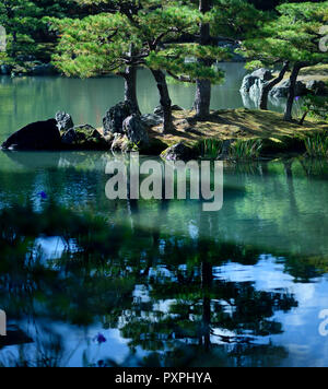 Ruhige Landschaft mit Kiefern auf einer Insel in einem Teich von einem japanischen Zen Garten mit schönen Spiegelungen im Wasser. Rokuon-ji Tempel, Kyoto, Japan. Stockfoto