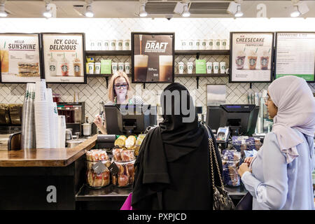 London England, Großbritannien, Soho Carnaby Street, Starbucks Coffee, Café Coffee House, Theke, Frau weibliche Frauen, Kassiererin, Gast, Muslim, Hijab, muslimische ethnische Barista Stockfoto