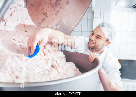 Metzger Erdung Fleisch in Grinder Maschine Würstchen zu machen Stockfoto