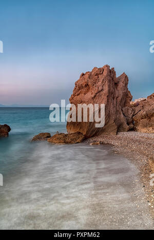 Lange Belichtung photograhy am felsigen Kato Petres Strand Landschaft in der Abenddämmerung. Rhodos, Griechenland Stockfoto