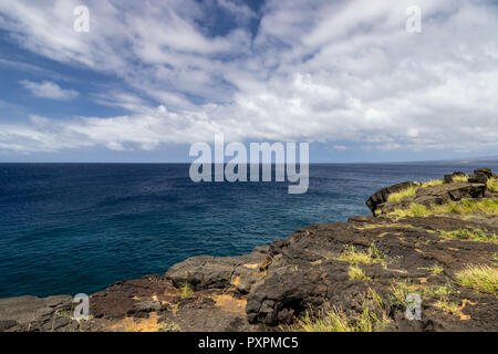 Blick von Süden auf Big Island von Hawaii. Lava Rock im Vordergrund; Pazifischer Ozean, blauer Himmel & Wolken im Hintergrund. Stockfoto
