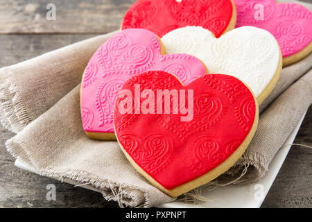 Herzförmige Plätzchen für den Valentinstag auf hölzernen Tisch Stockfoto