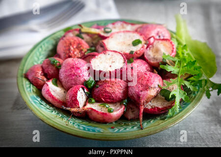 Auf dem Tisch auf einem Teller gebackenes Rettich mit grünen Zwiebeln und Kräutern. In enger vorgestellt. Stockfoto