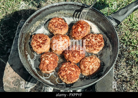 Am Lagerfeuer in einer großen Pfanne, gebratenen leckere Pasteten. Stockfoto