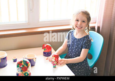 Kind, Mädchen spielen auf das Wohnzimmer mit Nesting Dolls Matrjoschka Stockfoto