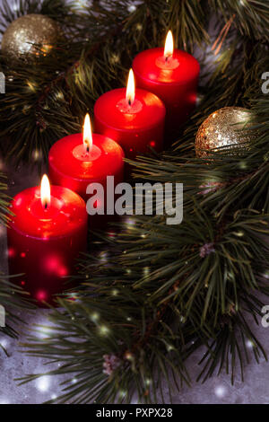 Vier rote beleuchtet advent Kerzen umgeben von grünen Tannenzweigen Stockfoto