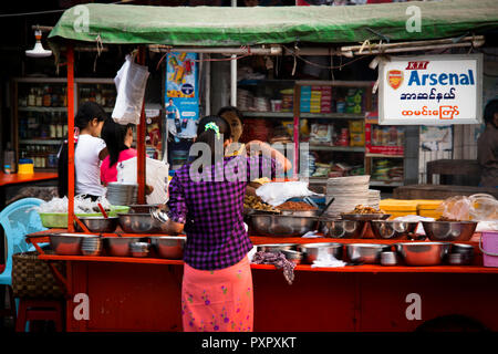MANDALAY, MYANMAR - MÄRZ 2018: Frau bying typische Straße Essen in Mandalay in Myanmar Stockfoto