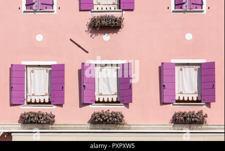 Detail eines eingerichteten rosa gefärbte Haus außen mit violetten Fensterläden Stockfoto