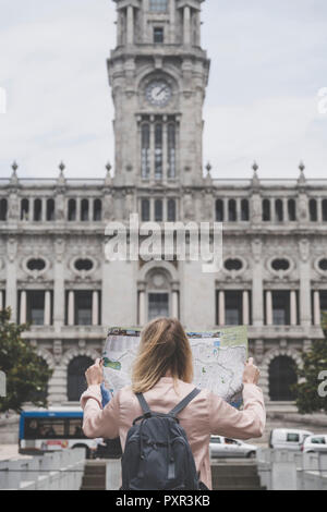 Portugal, Porto, Rückansicht der Tourist mit Rucksack auf Stadtplan vor Rathaus Stockfoto