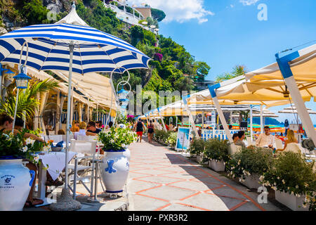 Restaurant Promenade Strand von Positano, Italien, farbenfrohes Bild perfekt Postkarte, Top Destinationen, Travel Concept Best Life, streifen Sonnenschirm, blau Stockfoto