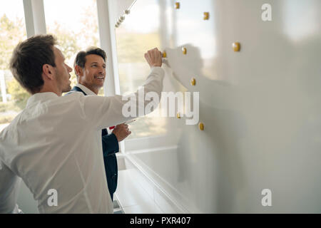 Reifen Geschäftsmann, wenn er sein Wissen mit jüngeren Kollegen Stockfoto