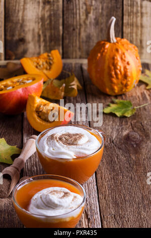 Butternut Kürbis Dessert im Glas Schale gekrönt mit Schlagsahne auf Holztisch close-up Stockfoto