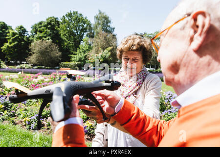Senior Paar spielen mit einer Drohne in Park Stockfoto