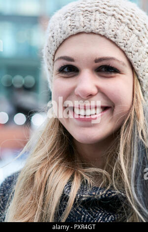 Portrait von lächelnden blonde junge Frau tragen wolle Gap im Winter Stockfoto