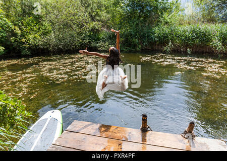 Sorglose Mädchen in den Teich springen Stockfoto