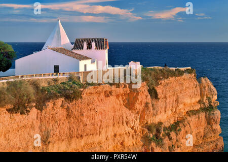 Weiß getünchten Kapelle auf einem Felsen durch blaue Meer umgeben Stockfoto