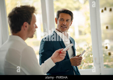 Reifen Geschäftsmann, wenn er sein Wissen mit jüngeren Kollegen Stockfoto