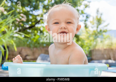 Junge in Baby Badewanne sitzen Stockfoto