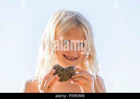 Portrait von blonde Mädchen mit Herz in den Händen Stockfoto