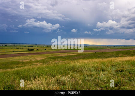 Gewitterwolken füllen Sie den Himmel als Regen im Hintergrund über das Pine Ridge, South Dakota von Nebraska fällt. Stockfoto