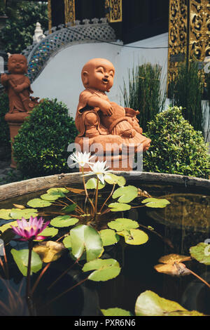 Thailand, Chiang Mai, Buddhastatuen und Teich von Seerosen in Wat Inthakhin Sadue Muang Tempel Stockfoto