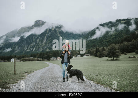 Österreich, Vorarlberg, Mellau, Mutter mit Kleinkind auf den Schultern auf einer Reise in die Berge Stockfoto