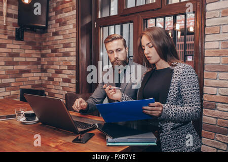 Business Meeting in Cafe - zwei Menschen, Mann und Frau, über ihre Pläne und Berichte. Stockfoto