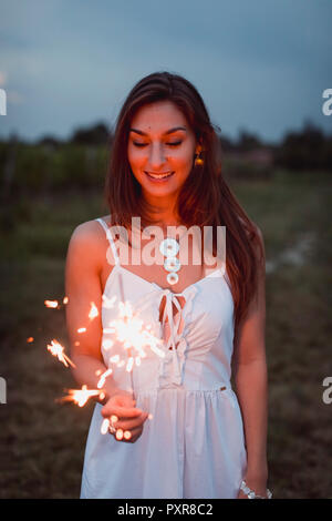 Junge Frau in Natur, brennende wunderkerze am Abend Stockfoto
