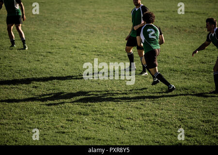 Männer spielen ein Spiel von Rugby auf einem Sportplatz. Rugby Spieler in Aktion auf die Tonhöhe während des Spiels. Stockfoto