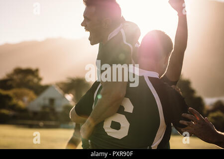 Sportler jubeln und schreien vor Freude nach dem Sieg. rugby-Team feiert den Erfolg nach dem Spiel. Stockfoto
