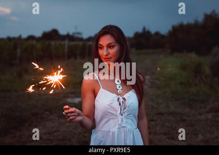 Junge Frau in Natur, brennende wunderkerze am Abend Stockfoto