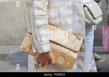 Mailand, Italien - 22. SEPTEMBER 2018: Frau mit beige Reptil leder tasche und weiß gestreifte Jacke vor ermanno Scervino fashion show, Milan Mode W Stockfoto