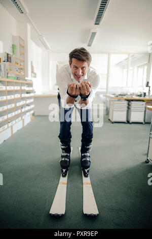 Geschäftsmann Skifahren im Büro Stockfoto