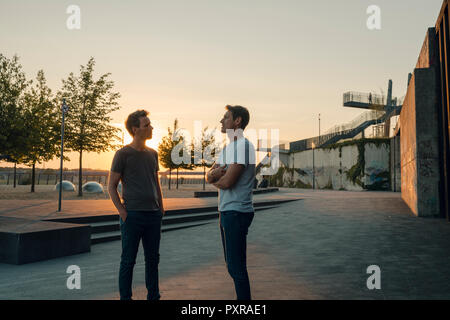 Zwei Freunde treffen bei Sonnenuntergang, am Abend reden Stockfoto